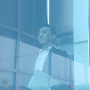 Man looking out window of high rise building