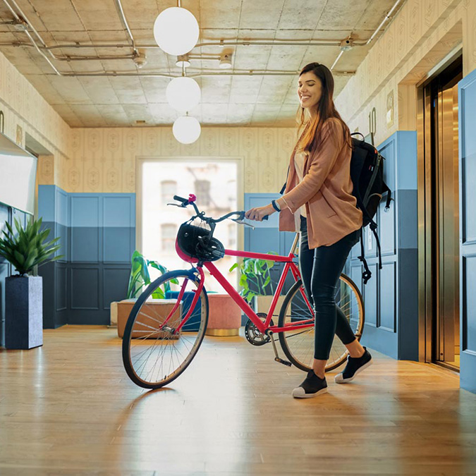 Woman walking a bike out of the elevator
