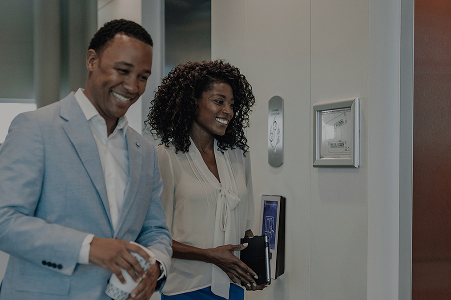 man and woman smiling as they enter an elevator