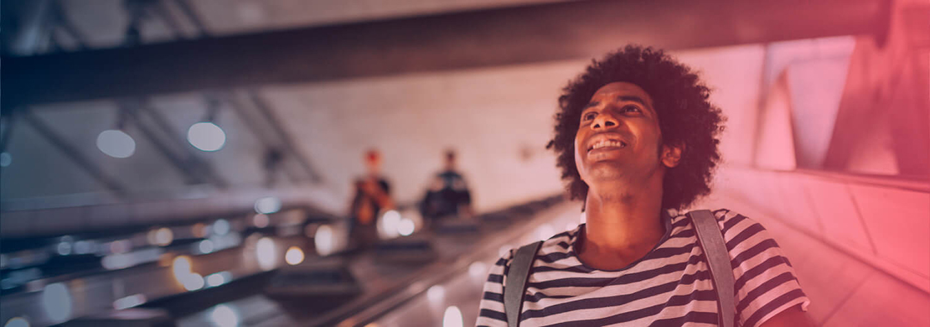 Man smiling going down an escalator
