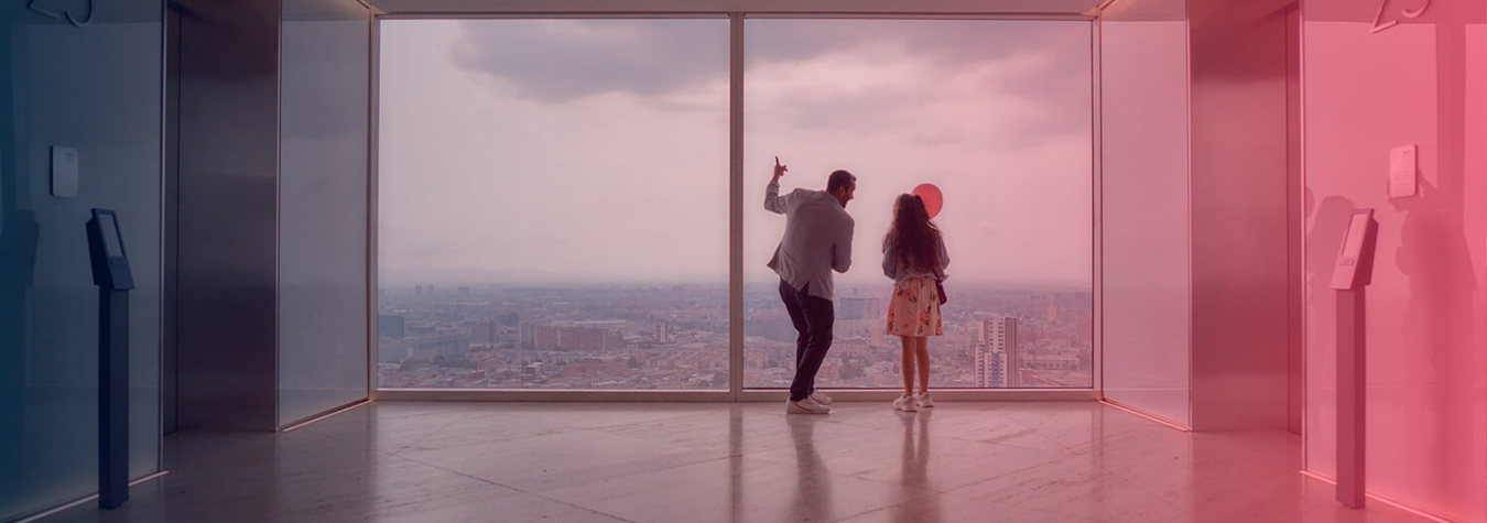 Man in wheelchair having coffee with colleague on roof of a building