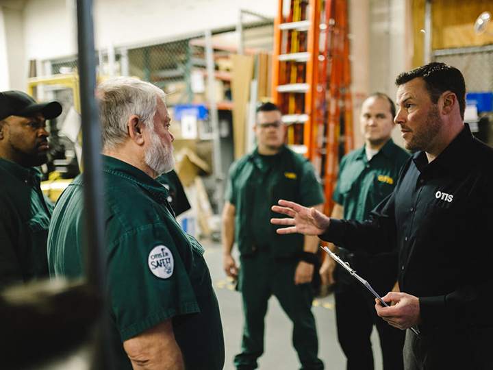 5 Otis workers discussing