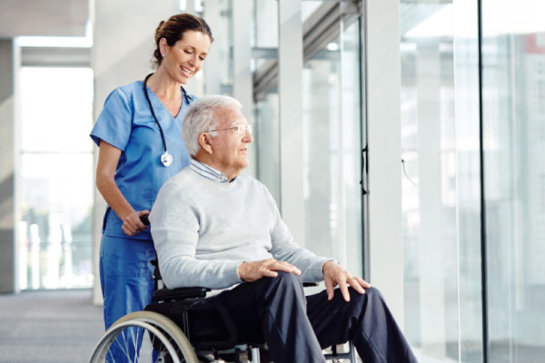 Man in wheelchair being pushed by nurse