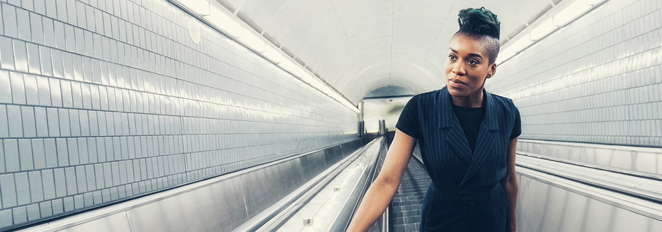 Woman riding up an Otis escalator